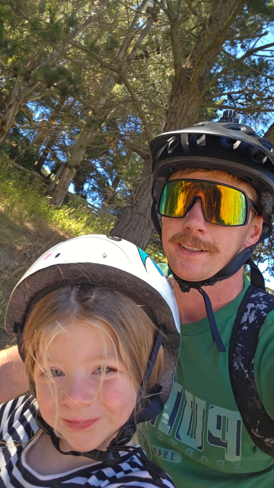 Michael on the bike trails with his daughter, both wearing helmets